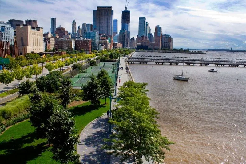 Waterfront park with courts by Manhattan's skyline.