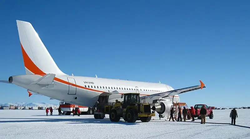 Plane parked on the vast white expanse of Antarctica's Ice Runway.