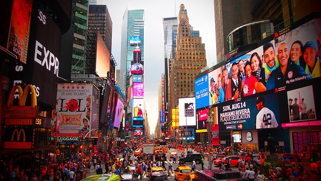 A vibrant view of a crowded block in New York City, showcasing the hustle and bustle of urban life with bright billboards, dense traffic, and a multitude of people, encapsulating the essence of what visitors should know before stepping into the energetic and ever-moving city.