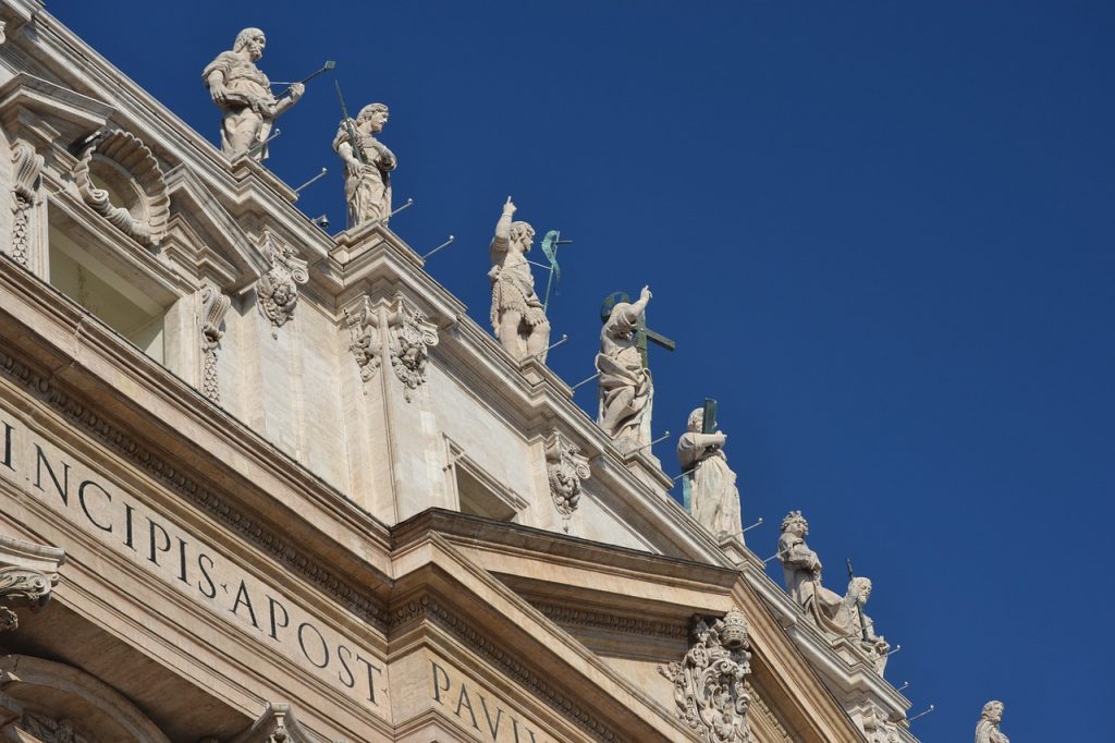 A panoramic photograph capturing the essence of Vatican City, with a view of its iconic structures including the dome of St. Peter's Basilica and the Vatican Museums. The image portrays the city's historical and religious significance under a serene sky.