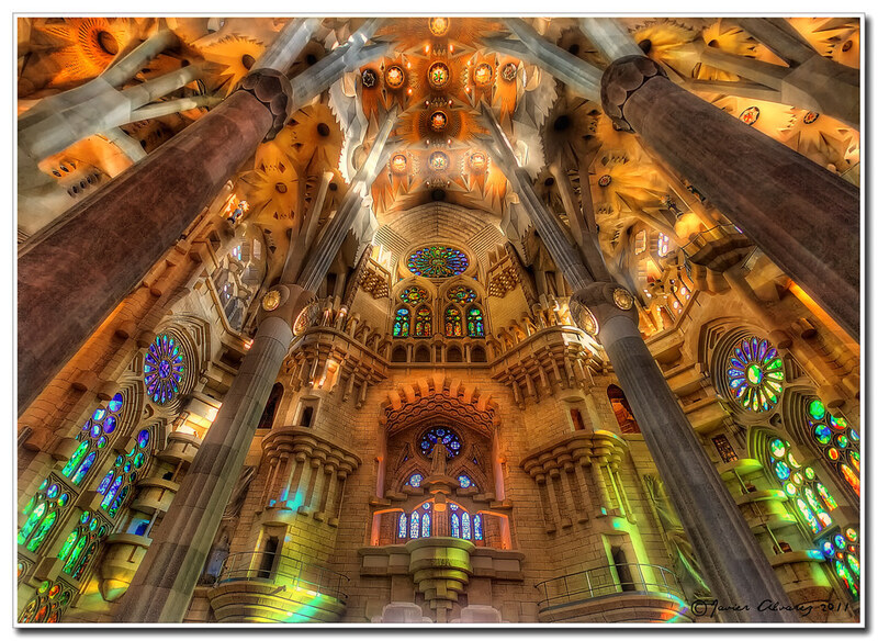 The interior of La Sagrada Família in Barcelona, a kaleidoscope of colors cast by stained glass windows, with towering columns and intricate ceiling details reflecting Antoni Gaudí's visionary design, creating a sense of otherworldly wonder.