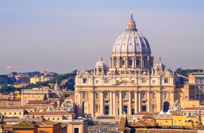 An awe-inspiring image showcasing the magnificent St. Peter's Basilica towering over the Vatican City landscape, its grandiose dome and ornate architecture standing out against the Roman skyline, highlighting the Vatican's renowned status as a monumental epicenter of art, history, and spirituality.
