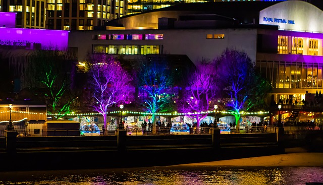 A nighttime view of London's South Bank, with the Royal Festival Hall in the background.
