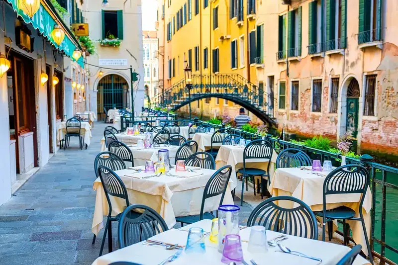 Venetian restaurant tables by a canal.