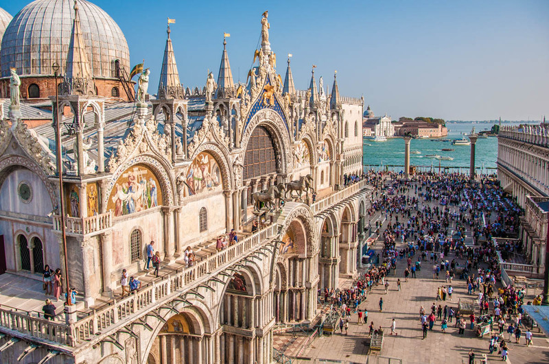 Crowded St. Mark's Basilica in Venice overlooking the sea.