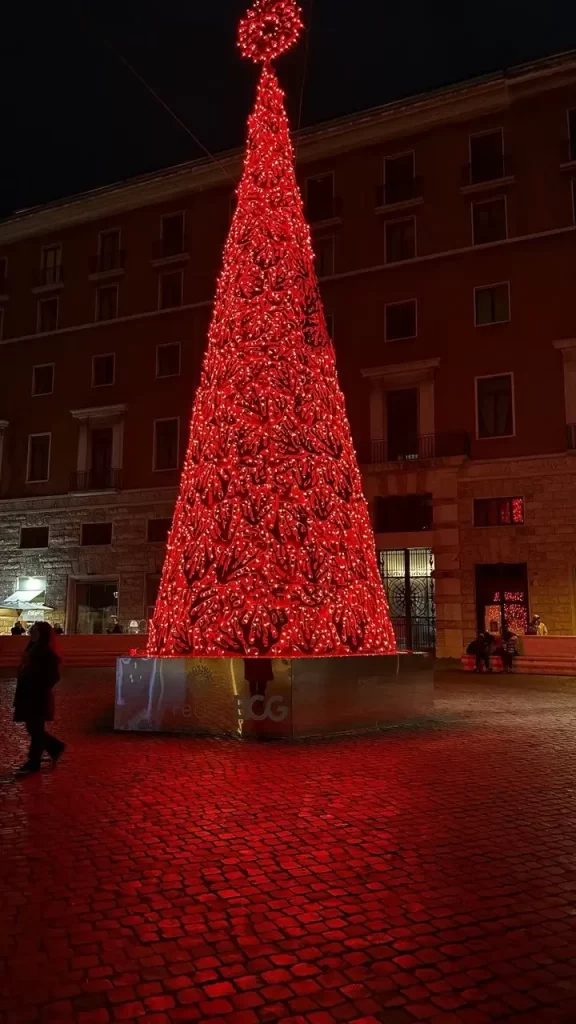Illuminated red Christmas tree at night in Rome