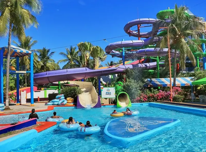 Visitors floating on a lazy river under vibrant water slides.