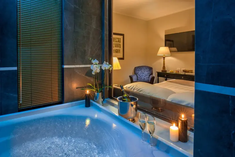 Chic room with a jacuzzi, champagne, and dim lighting.