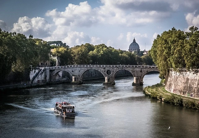 Boat on Tiber River with Rome's bridge and dome.