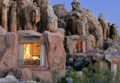 A unique hotel with rooms integrated into rocky cliffs at dusk.
